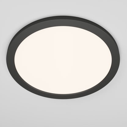 The Skylight Pro 15" 5K LED Flat Panel Light is an ultra-slim, round ceiling fixture with a black frame and a white illuminated center, flush-mounted on a light gray ceiling.